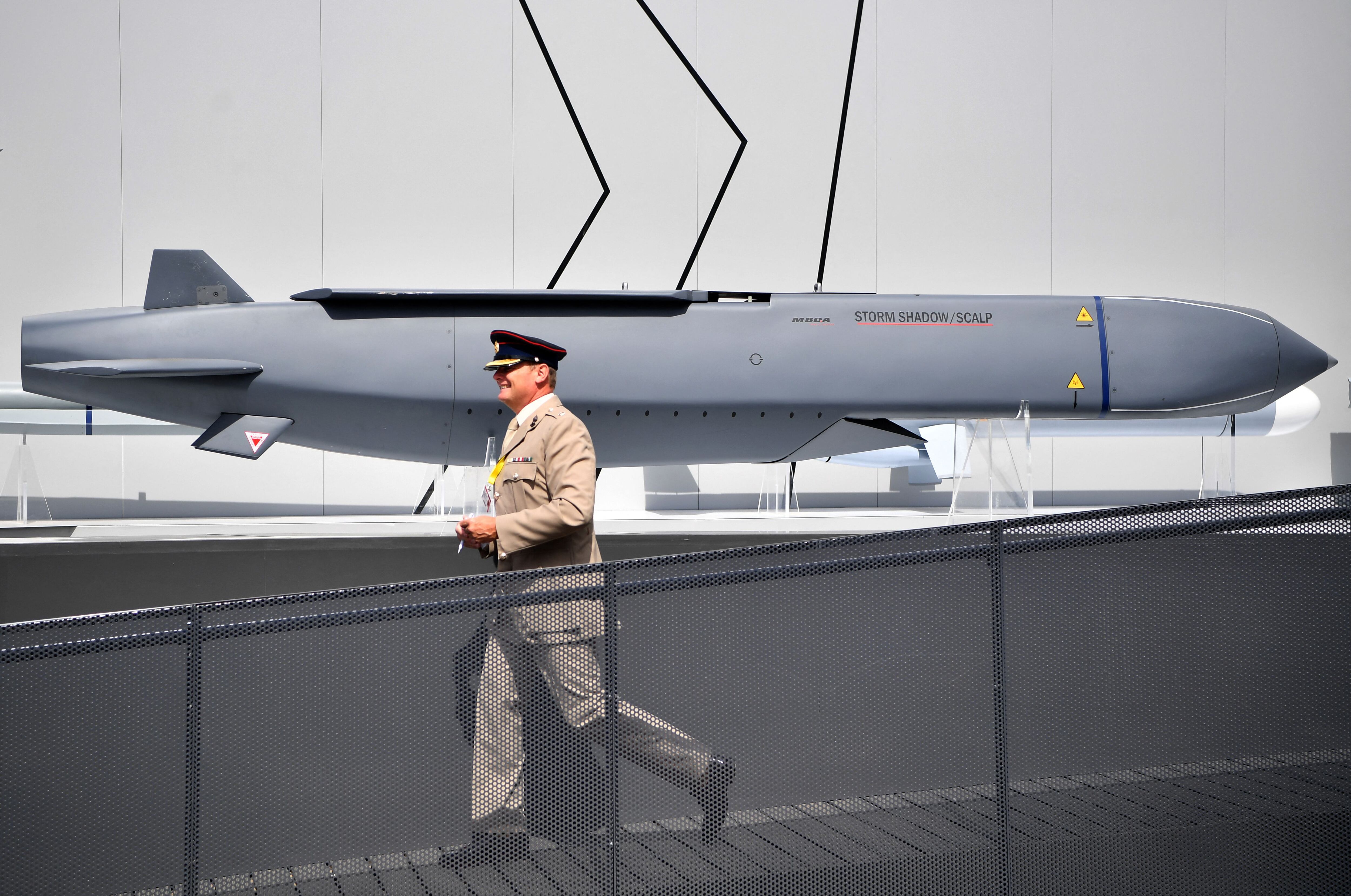 A military man walks past an MBDA Storm Shadow/Scalp missile at the Farnborough Airshow, southwest London, United Kingdom, on July 17, 2018. (Photo by BEN STANSALL/AFP).