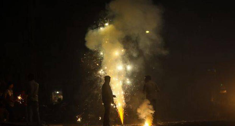 Varias personas encienden fuegos artificiales con motivo del festival de Diwali. (Foto: EFE)