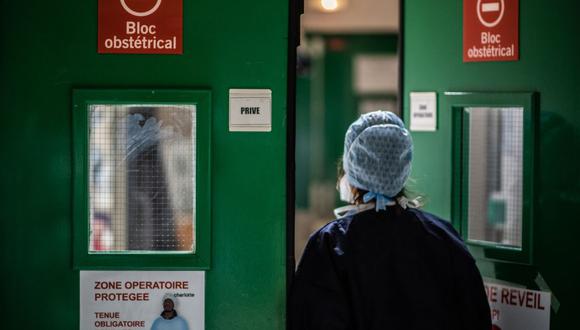 Una enfermera pasa por una puerta durante la pandemia de coronavirus Covid-19 en la maternidad del hospital Diaconisas en París, Francia. (MARTIN BUREAU / AFP).