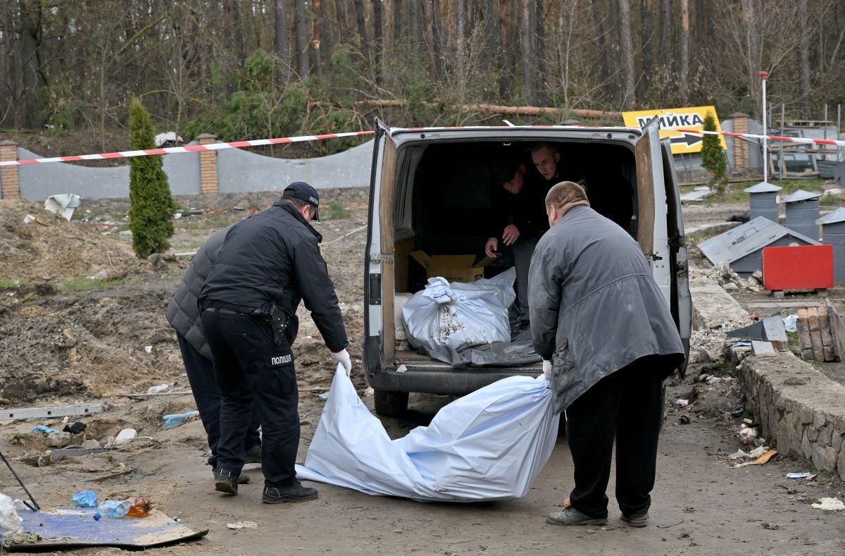 Ukrainian rescuers carry bodies that were discovered in a sewer at a gas station outside the village of Buzova, west of kyiv, on April 10, 2022. (Sergei SUPINSKY / AFP)