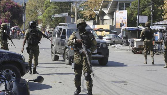 Elementos de la Unidad de Seguridad General del Palacio Nacional de Haití establecen un perímetro para retomar el control de una de las tres delegaciones de policía que fueron tomadas por pandillas, el sábado 9 de marzo de 2024. (AP Foto/Odelyn Joseph).