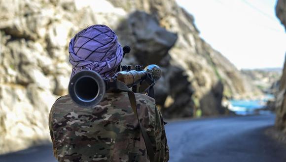 Un movimiento de resistencia afgano y personal de la fuerza de levantamiento contra los talibanes montan guardia con un arma a lo largo de una carretera en Rah-e Tang, en la provincia de Panjshir, el 25 de agosto de 2021. (Ahmad SAHEL ARMAN / AFP).