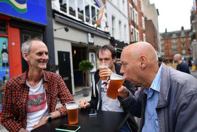 La gente bebe cerveza en una calle peatonal recién creada en Soho en Londres. Los pubs en Inglaterra vuelven a abrir el sábado por primera vez desde finales de marzo, cuando fueron cerrados debido a la pandemia de coronavirus. (Foto por JUSTIN TALLIS / AFP).