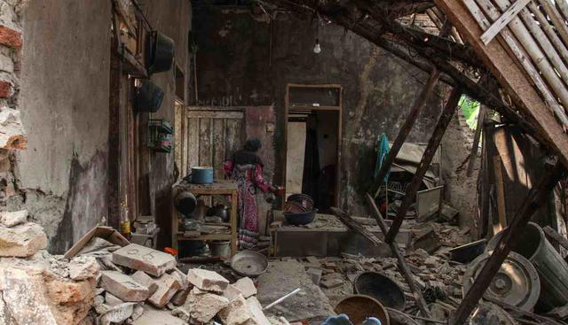 Una aldeana busca sus pertenencias en su casa de daños en Pandeglang, provincia de Banten, el 3 de agosto de 2019, después de un fuerte terremoto de 6,9 grados que sacudió a Indonesia la noche del viernes. (Foto: AFP)