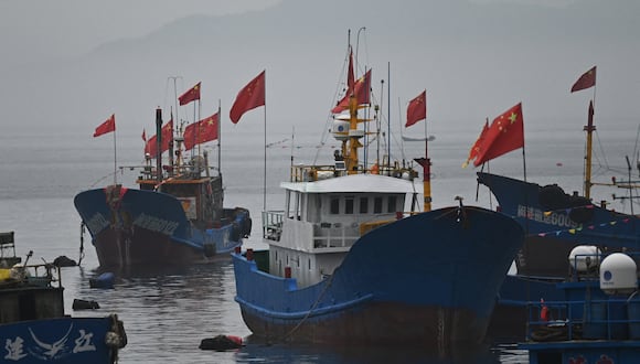 Banderas chinas ondean en barcos pesqueros en la aldea de Tailu, en la costa china frente a las islas Matsu de Taiwán, en la provincia de Fujian, en el sureste de China, el 25 de mayo de 2024. (Foto de GREG BAKER / AFP)