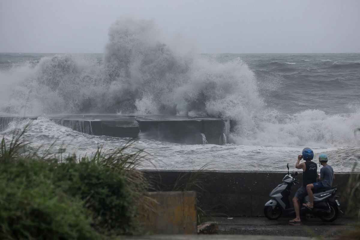 La gente observa enormes olas en Yilan cuando el tifón Haikui toca tierra en el este de Taiwán el 3 de septiembre de 2023. (Foto de I-Hwa Cheng / AFP)