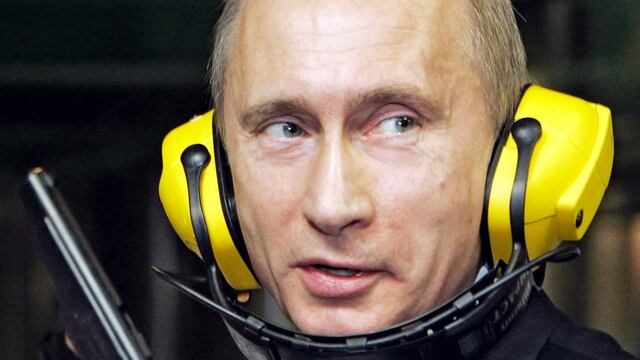 El presidente de Rusia, Vladimir Putin, sostiene una pistola durante su visita a la recién construida sede del Departamento Principal de Inteligencia del Estado Mayor ruso (GRU), el 8 de noviembre de 2006. (FOTO: AFP).
