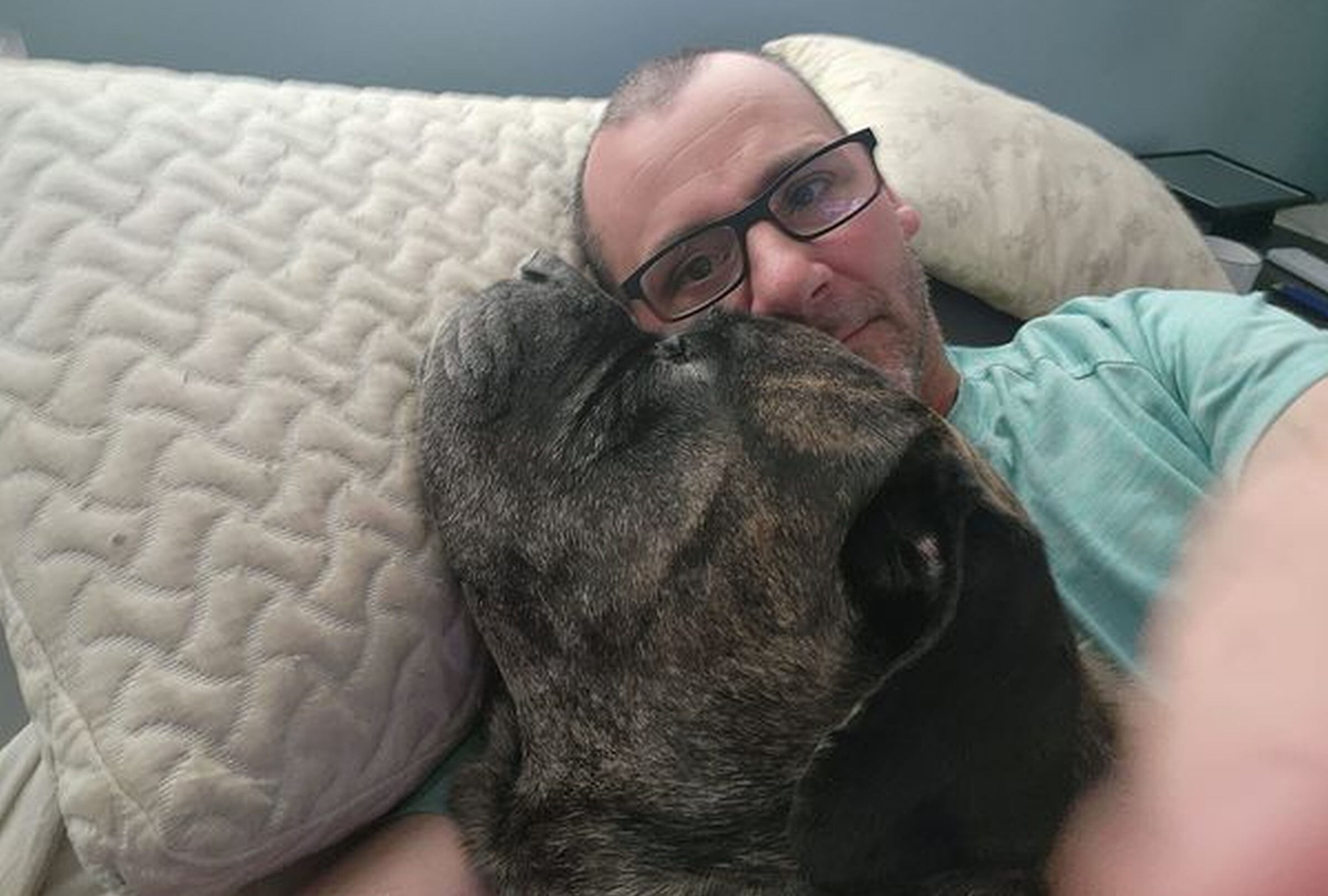 Esta imagen permite apreciar a Gator echado con su dueño Travis. (Foto: Mastiff Rescue of Florida, Inc / Facebook)