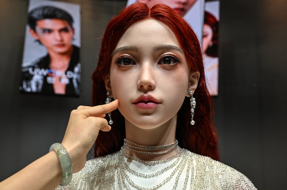 Una mujer toca el rostro de un robot humanoide durante el lanzamiento del robot U1, fabricado por UWORLD, una marca de UBTECH Robotics. (Foto: AFP)