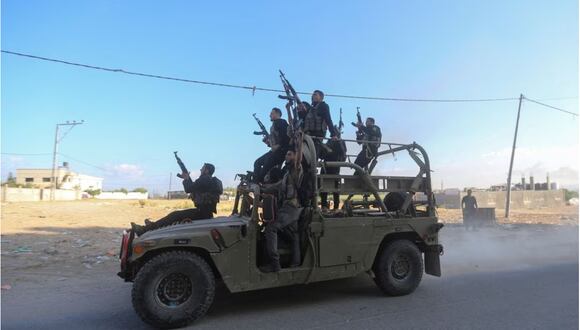 Militantes palestinos viajan en un vehículo militar israelí que fue incautado por hombres armados que se infiltraron en áreas del sur de Israel, en el norte de la Franja de Gaza, el 7 de octubre de 2023. (REUTERS/Ahmed Zakot).
