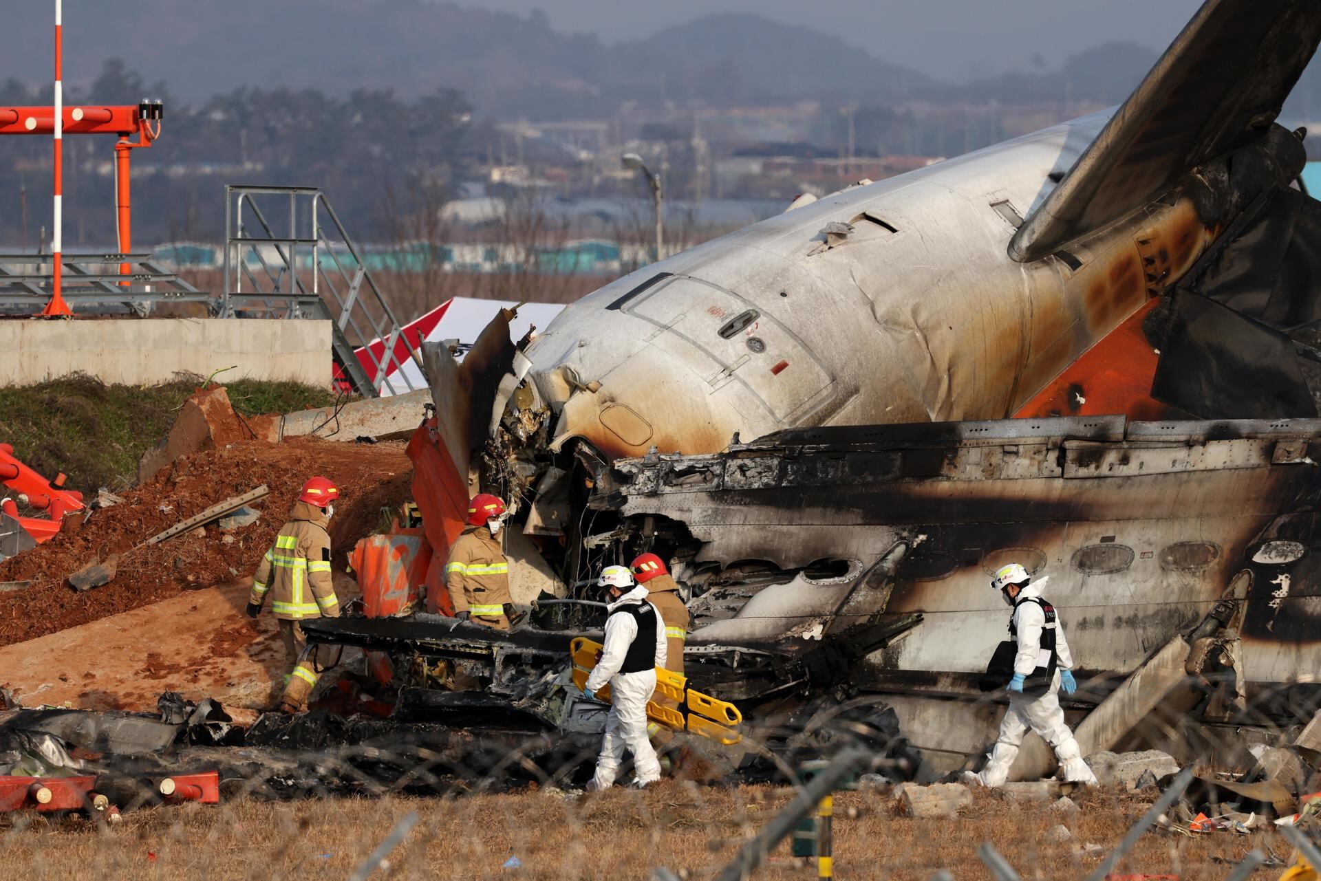 Los bomberos buscan entre los restos del avión Jeju Air estrellado en el Aeropuerto Internacional de Muan, en Corea del Sur. (EFE/EPA/HAN MYUNG-GU).