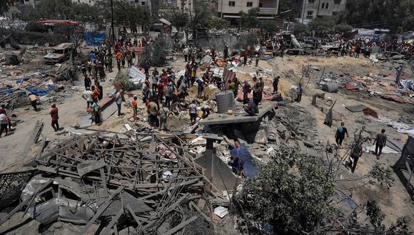Los palestinos observan los escombros de las tiendas de campaña destruidas y las estructuras de viviendas improvisadas tras un ataque militar israelí contra el campamento de desplazados internos (PDI) de al-Mawasi, cerca de la ciudad de Khan Yunis, en el sur de la Franja de Gaza, el 13 de julio de 2024. (Foto de Bashar TALEB / AFP)