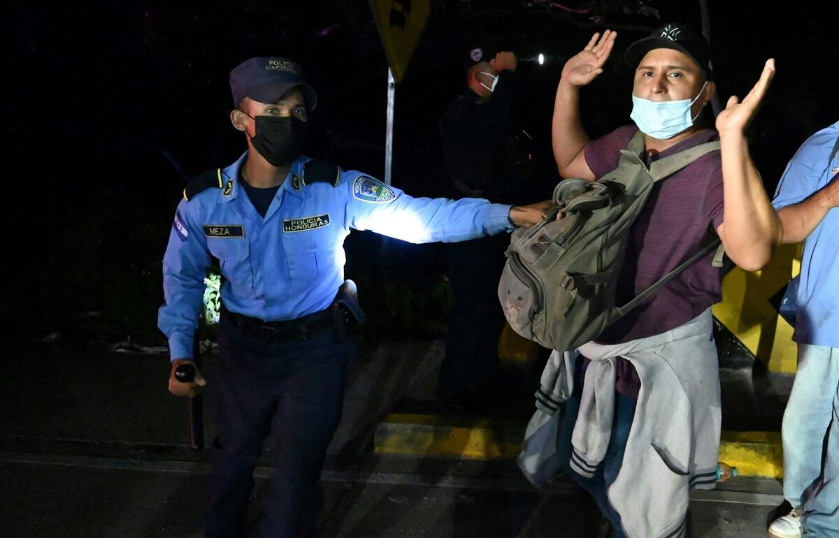 Un migrante hondureño que se dirige a la frontera con Guatemala, es detenido por la policía en el municipio de El Florido, en el departamento hondureño de Copán, el 15 de enero de 2021, en su camino a Estados Unidos. (Foto de Orlando SIERRA / AFP)