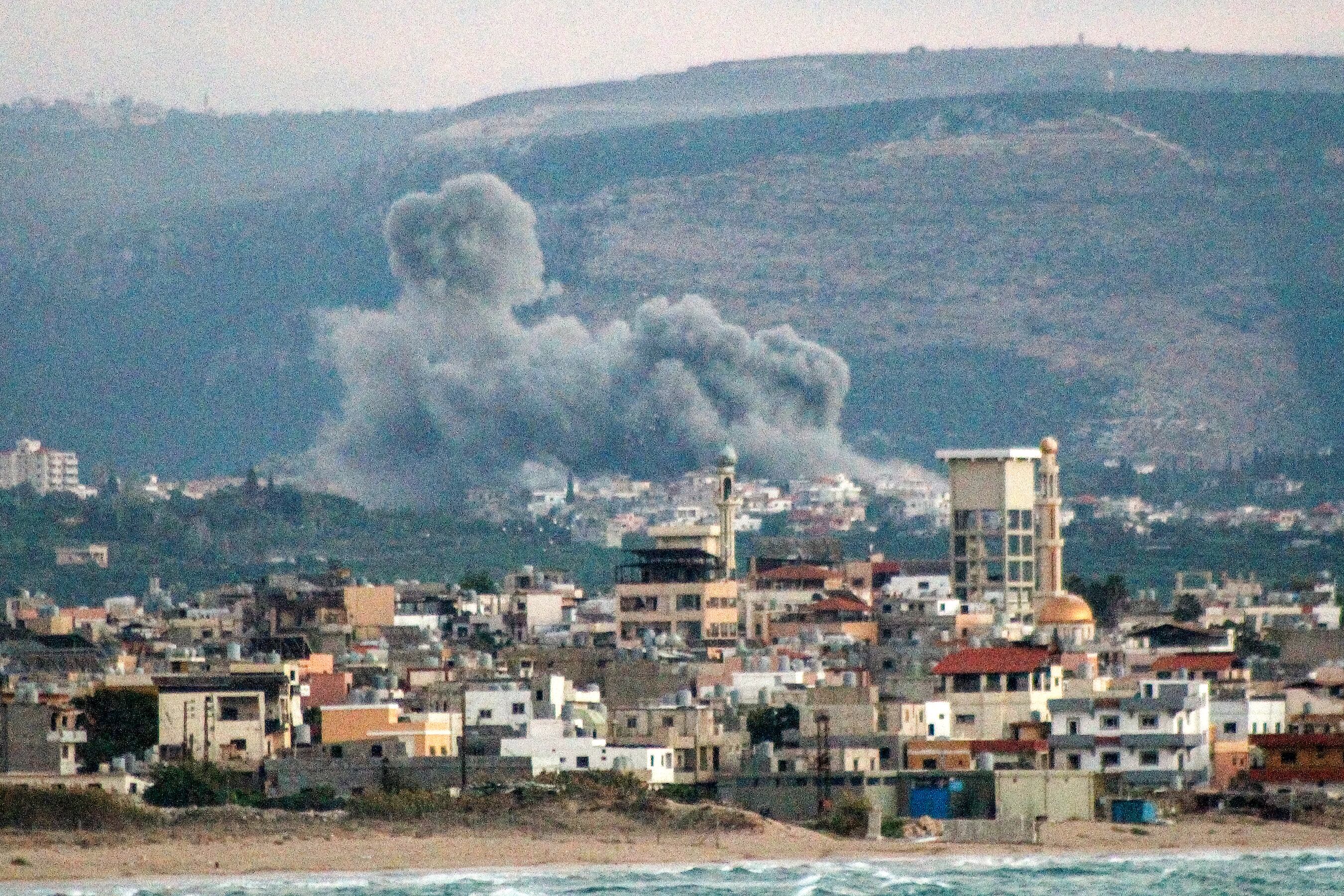 Esta vista panorámica de la ciudad de Tiro, en el sur del Líbano, muestra una nube de humo que surge tras un ataque aéreo israelí en la aldea de Qlayleh el 30 de septiembre de 2024. (Foto de Kawnat HAJU / AFP)