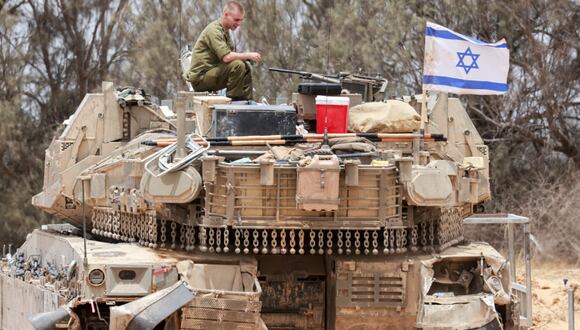 Un soldado israelí sentado encima de un tanque en una zona de despliegue cerca de la frontera sur de Israel con la Franja de Gaza el 28 de mayo de 2024, en medio del conflicto en curso entre Israel y el grupo militante Hamás. (Foto de Menahem KAHANA / AFP)