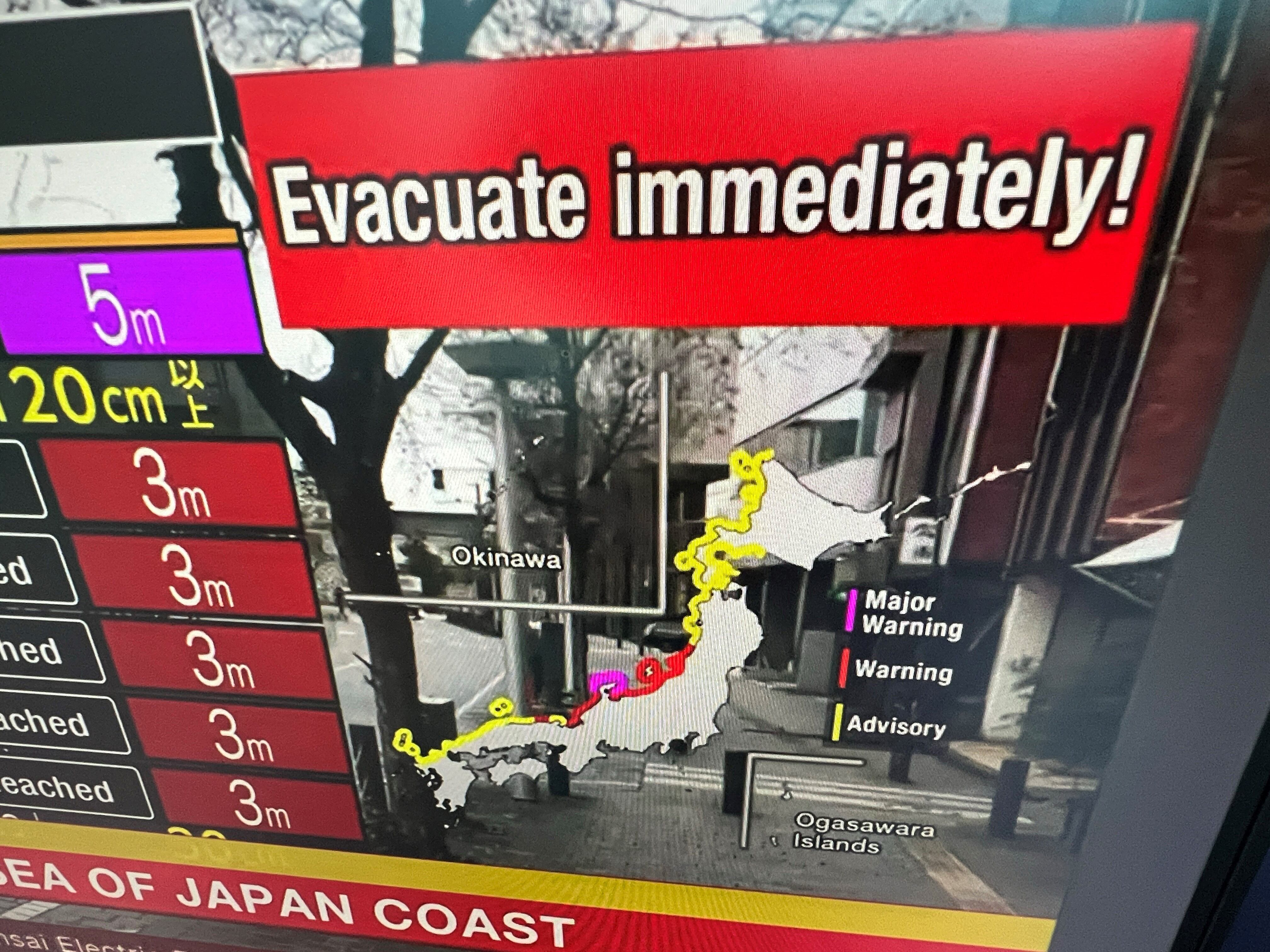 Esta imagen tomada en Hong Kong el 1 de enero de 2024 muestra un mensaje de advertencia en una pantalla de una transmisión en vivo de NHK World pidiendo a la gente que evacue el área después de un terremoto en Japón. (Foto de Mladen ANTONOV / AFP).