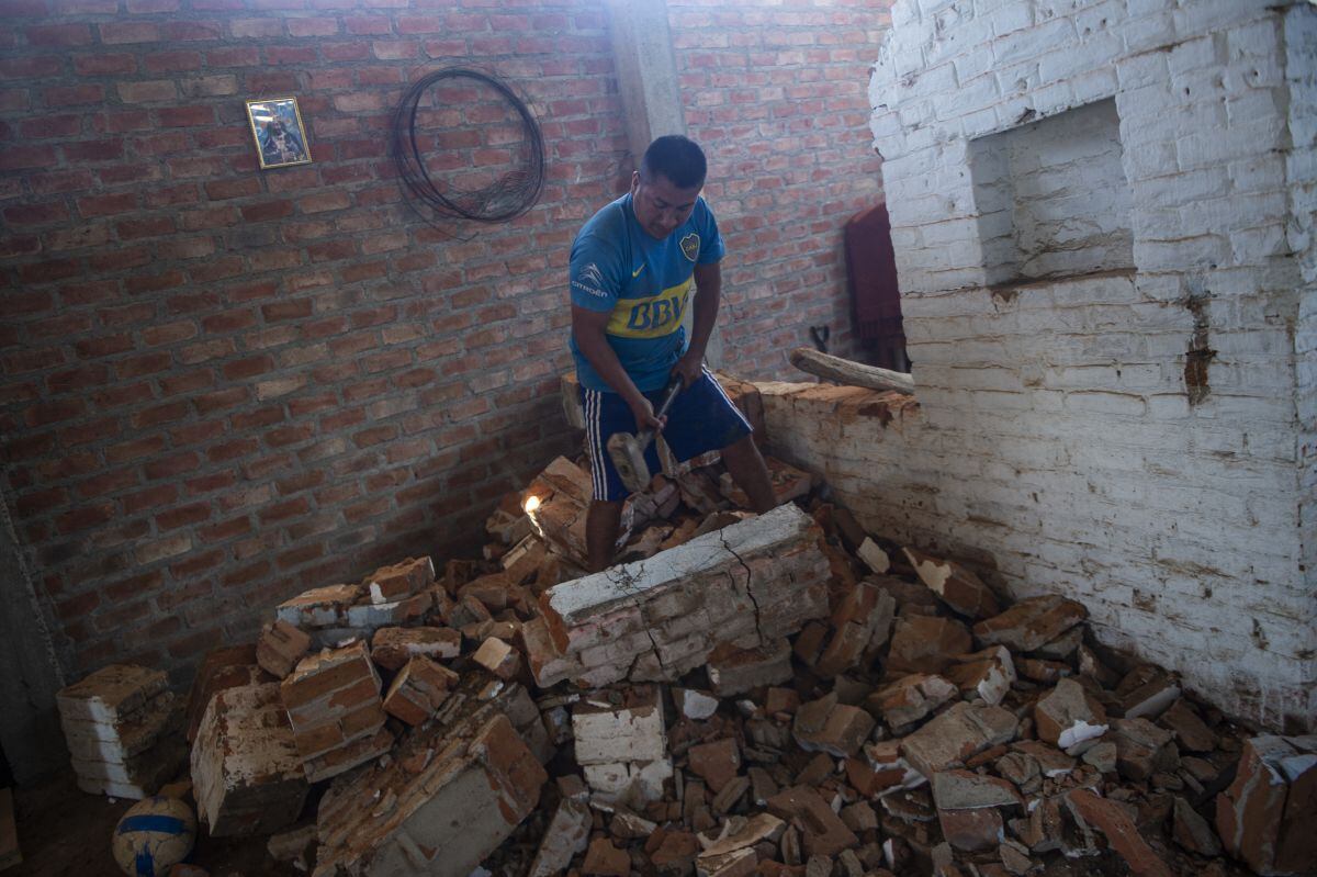 Un hombre arregla su casa, dañada por las inundaciones durante el fenómeno de El Niño Costero, en el distrito de Pedregal en Piura (Perú), el 17 de octubre de 2021 (Foto: Ernesto Benavides / AFP)