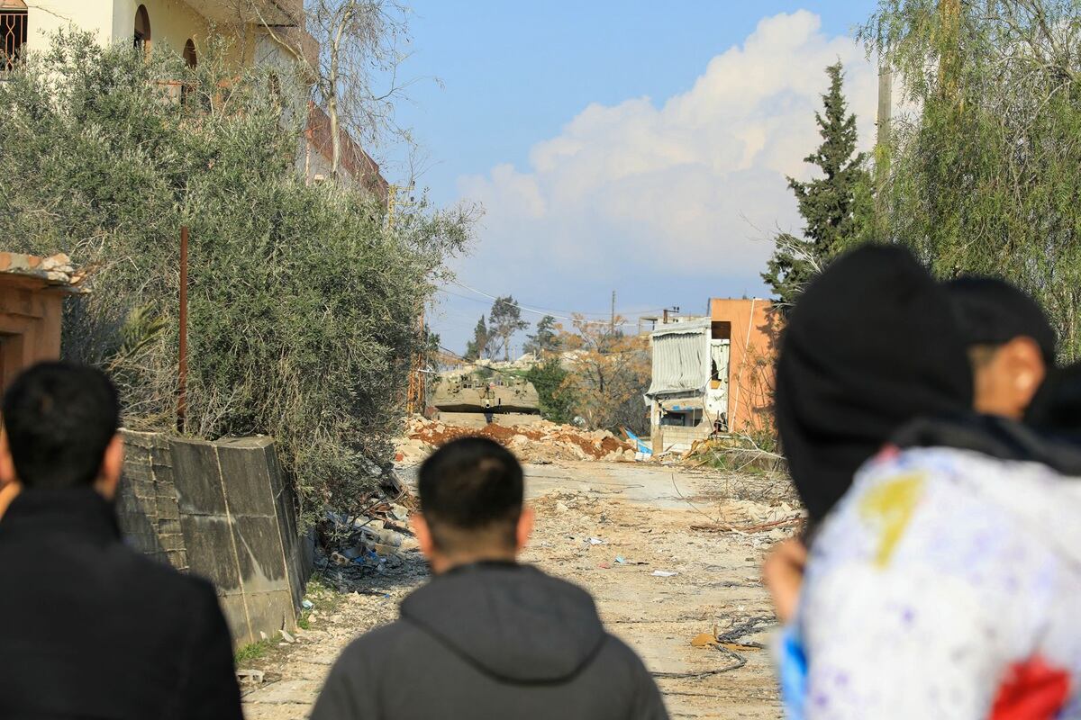 Residentes libaneses observan un tanque del ejército israelí que bloquea la entrada de su aldea sureña de Houla, impidiendo su regreso a la ciudad, el 27 de enero de 2025. (Foto de AFP)
