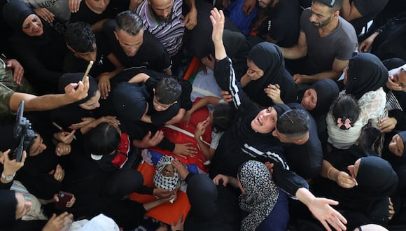 Los palestinos lloran durante el funeral de un hombre que presuntamente murió cuando detonó un artefacto explosivo que estaba fabricando, en el campo de refugiados de Balata, en la Cisjordania ocupada el 21 de junio de 2023. (Foto de Jaafar ASHTIYEH / AFP)