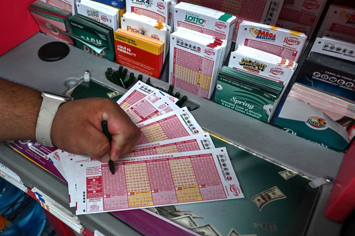 Una mujer llena boletos de lotería Powerball dentro de una tienda en Homestead, Florida (Foto: Giorgio Viera / AFP)