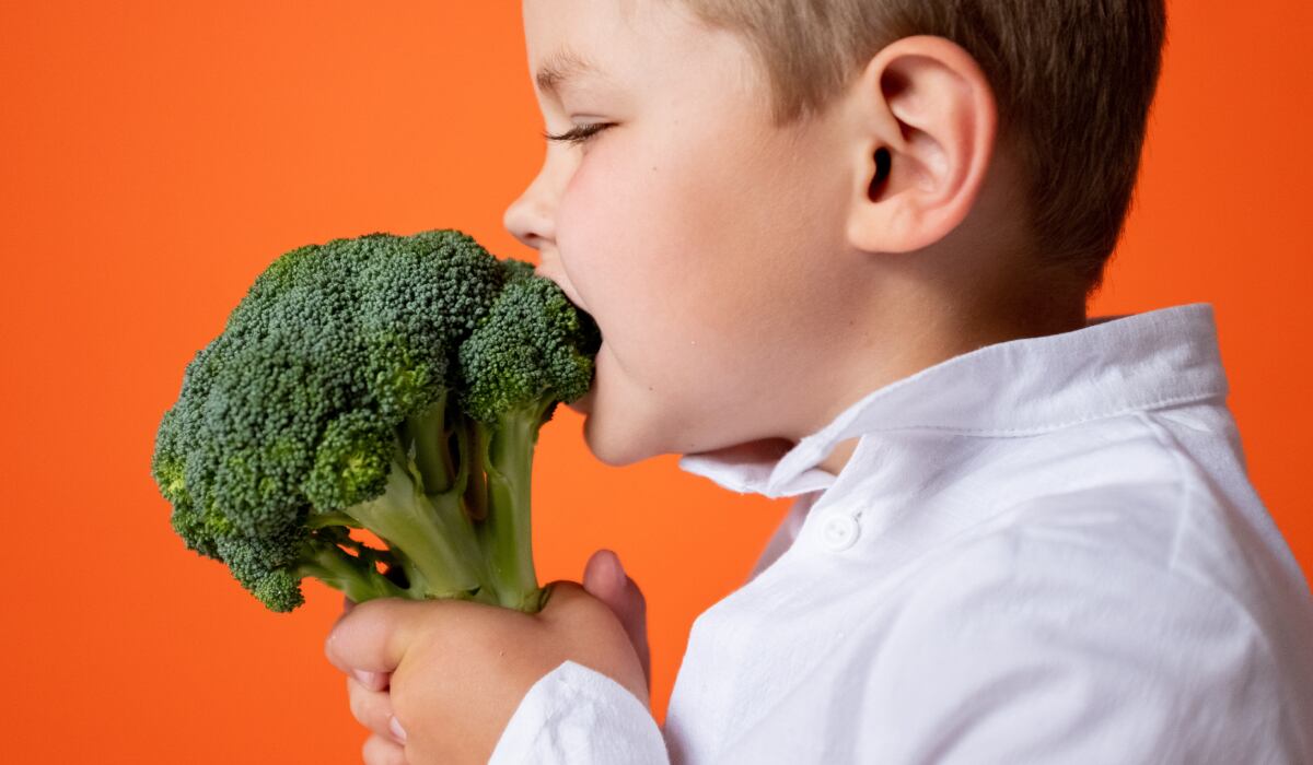 Niño con camisa blanca muere un brócoli. (Imagen: cottonbro studio / Pexels)