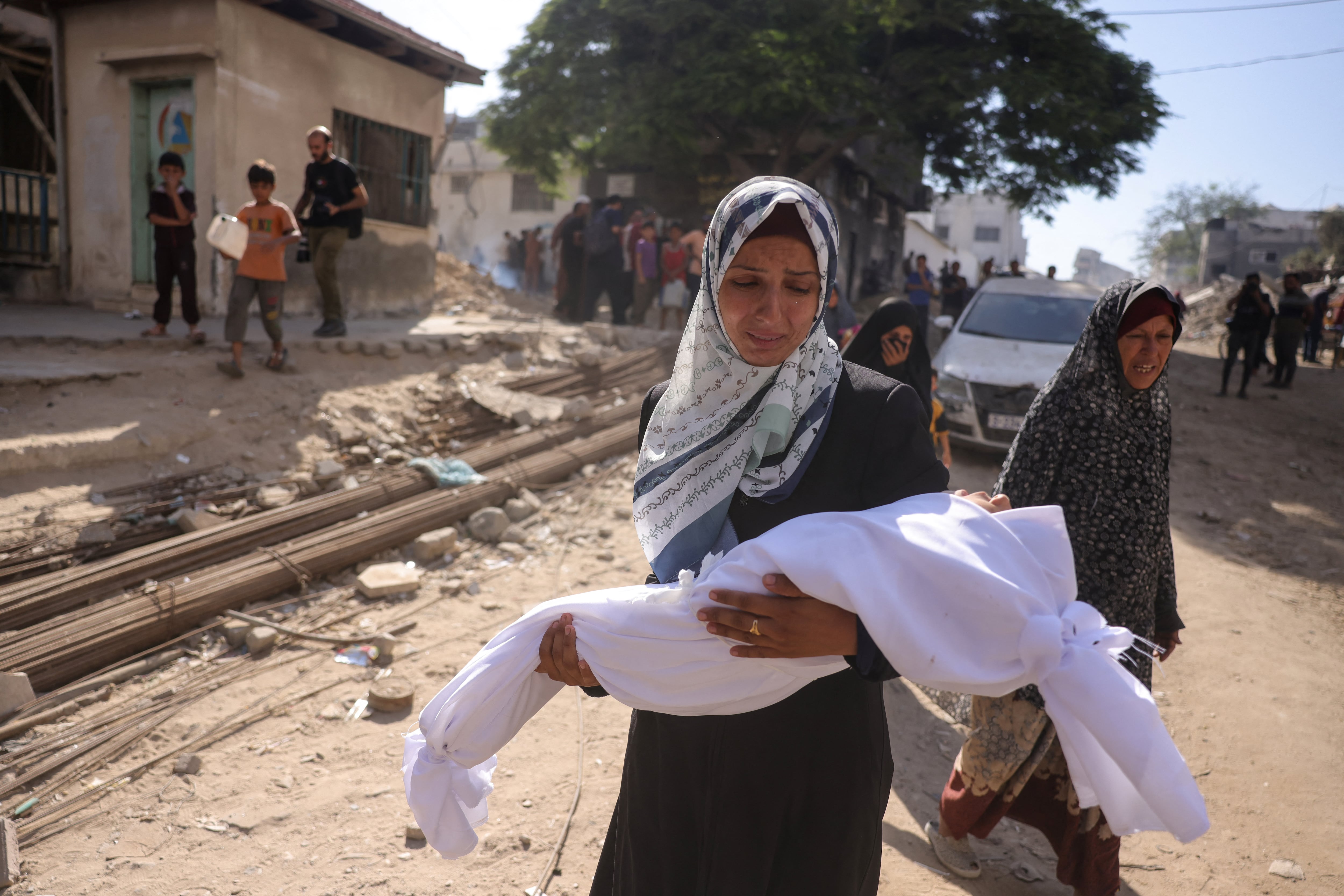 Una mujer palestina carga el cuerpo de un niño frente al hospital Shifa en la ciudad de Gaza, donde fueron trasladados los heridos por un ataque de Israel, el 29 de agosto de 2025. (Foto de BASHAR TALEB / AFP).