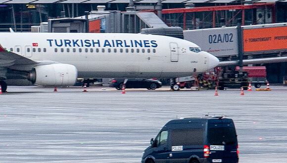 A police van observe the car of a hostage taker seen parked under a Turkish airline plane on the tarmac at the airport in Hamburg, northern Germany on November 5, 2023. Air traffic at Hamburg airport remained suspended Sunday over a suspected hostage situation on the tarmac involving a child, local authorities said.
A gunman rammed his car through the security area onto the apron where planes are parked on Saturday evening, firing two shots in the air and flinging two burning bottles out of the vehicle, police said. (Photo by NEWS5 / Schr�der / NEWS5 / AFP)