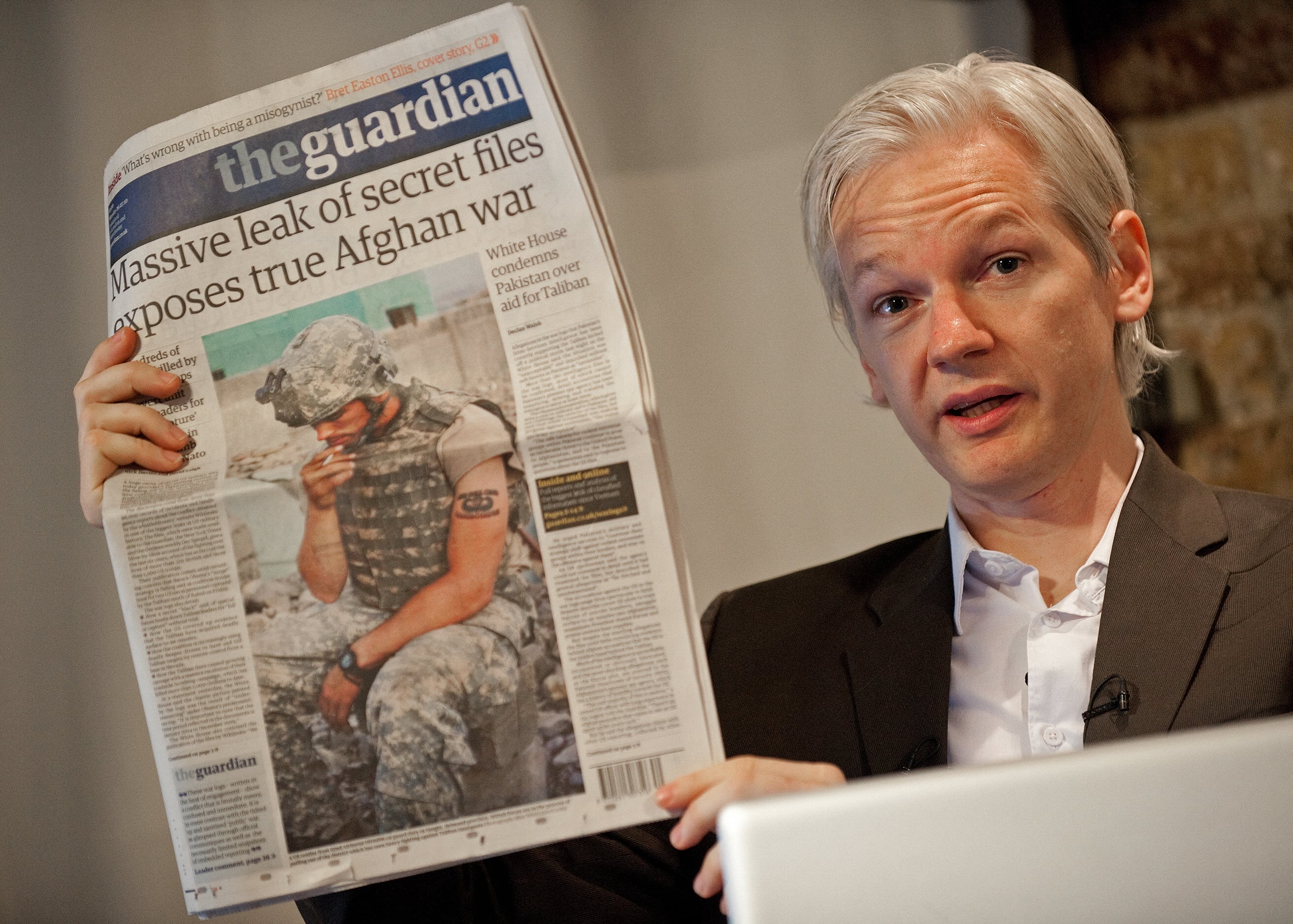 Julian Assange sostiene una copia del periódico The Guardian durante una conferencia de prensa en Londres el 26 de julio de 2010. (Foto de LEON NEAL / AFP).