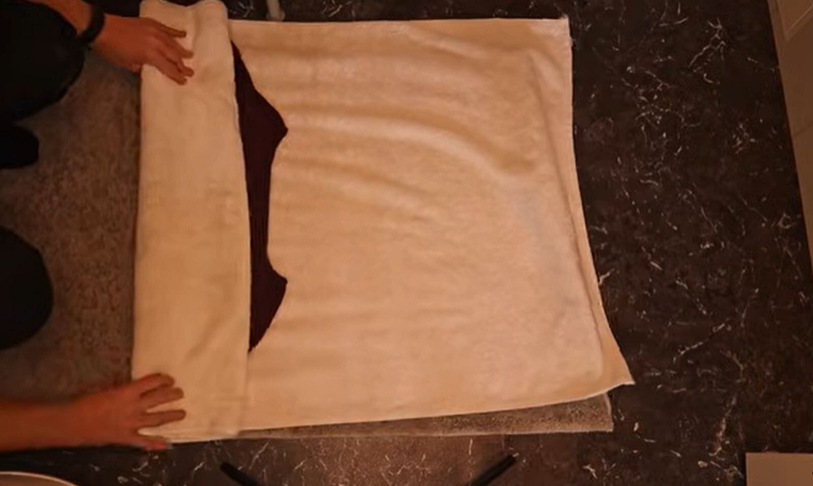 TRUCOS CASEROS | La prenda mojada debe quedar enrollada en la toalla. (Foto: @Organizing-TV / YouTube)