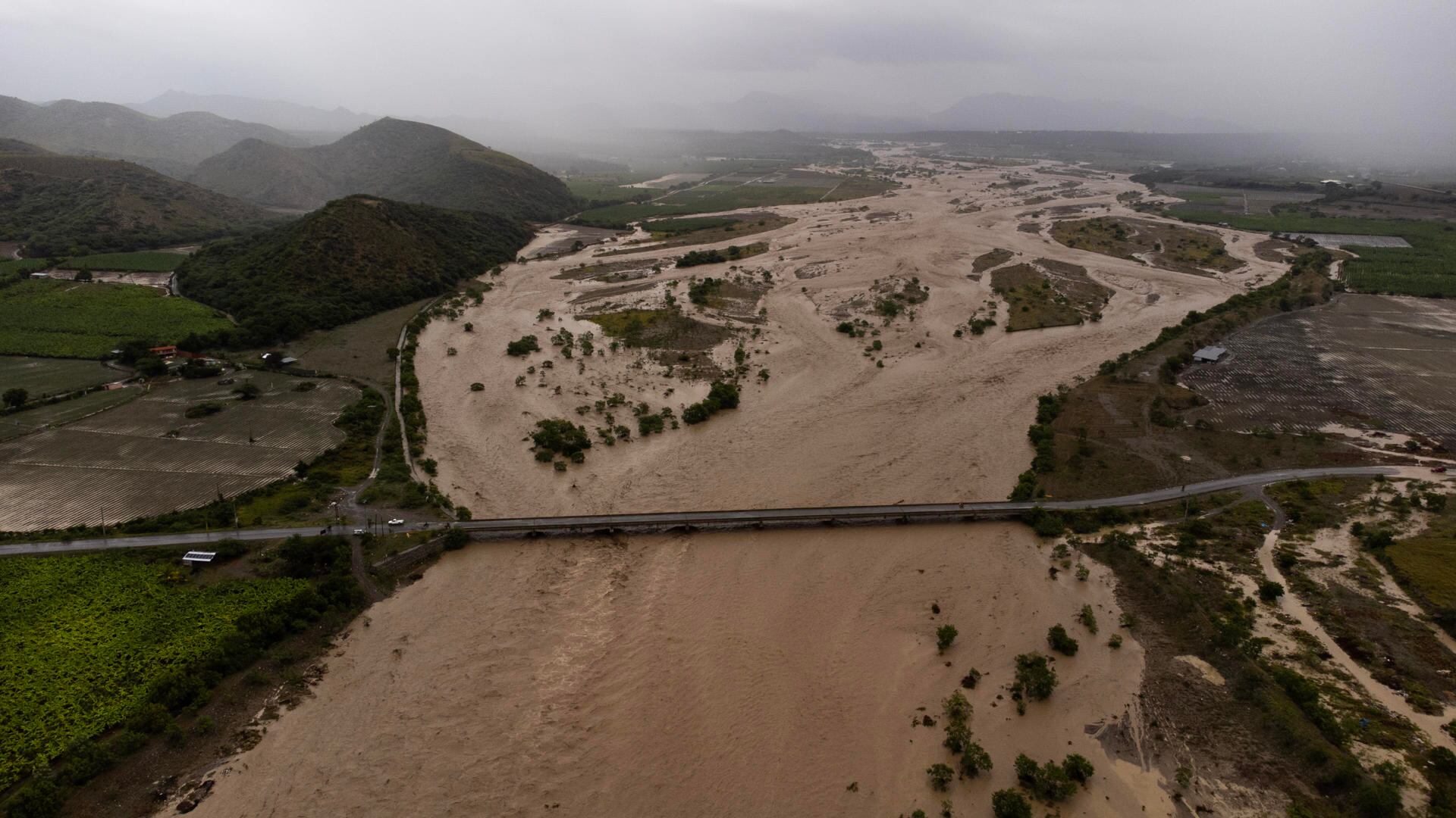 Fotografía aérea que muestra el Río Ocoa completamente desbordado y con un intenso caudal producto de la fuertes lluvias en Palmar de Ocoa, República Dominicana. (EFE/Orlando Barría).