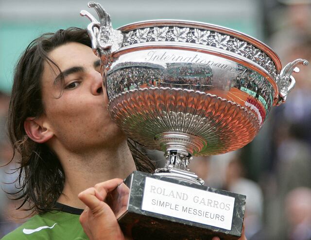 Rafael Nadal besa su trofeo tras el partido final masculino del Abierto de Francia de tenis en Roland Garros contra el argentino Mariano Puerta, el 5 de junio de 2005 en París. (Foto: AFP)