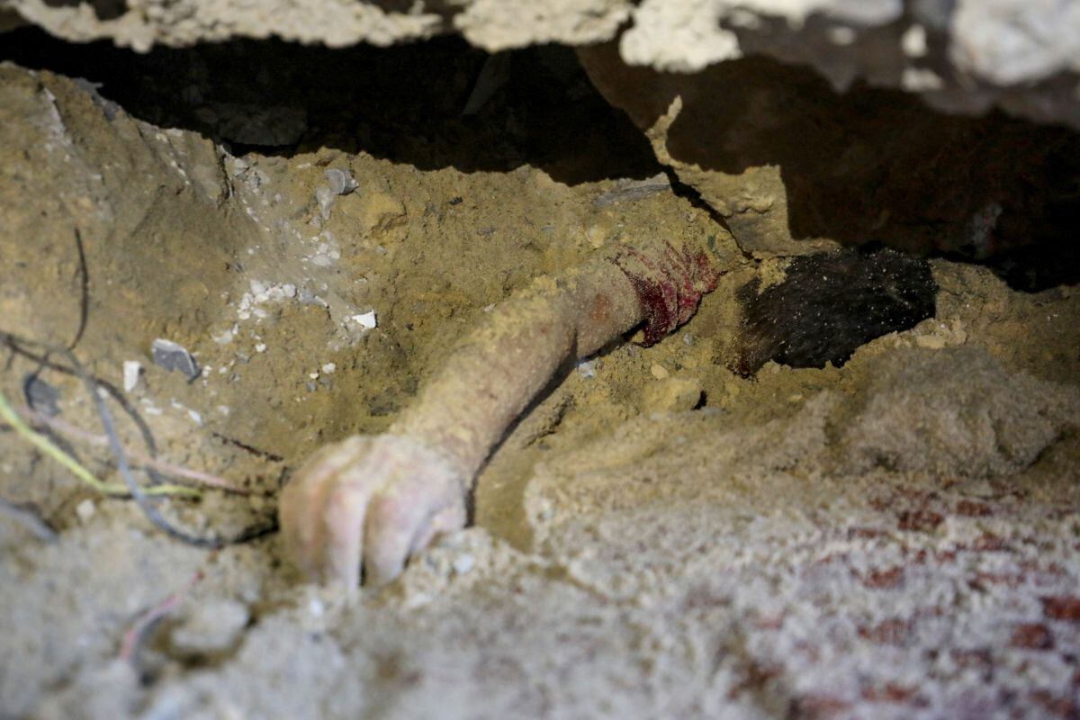 El cuerpo de un niño yace enterrado bajo los escombros de un edificio alcanzado por un ataque israelí en el campo de refugiados de Nuseirat. Foto: Eyad BABA / AFP