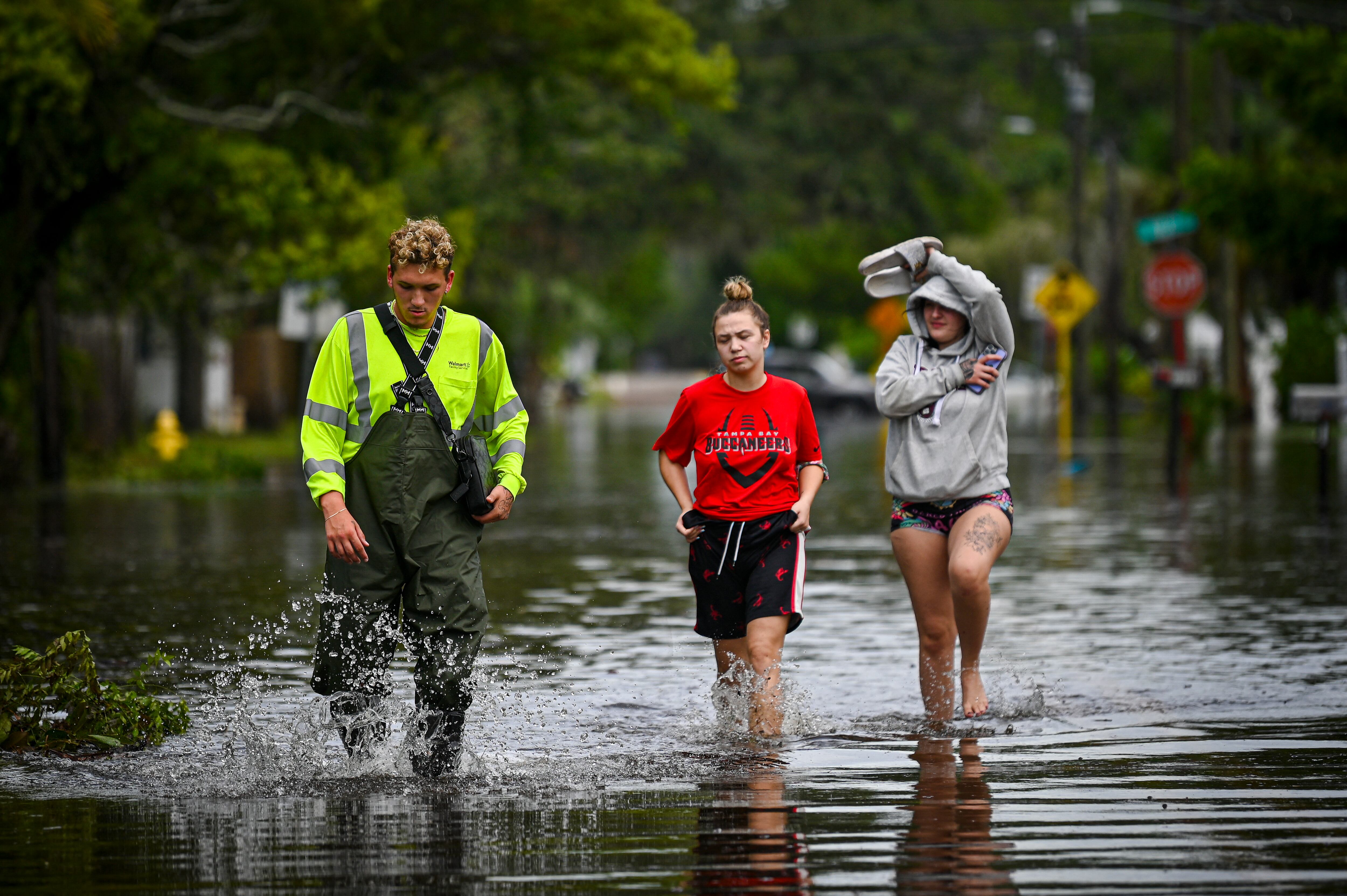 La gente camina por las calles inundadas en New Port Richey, Florida, el 30 de agosto de 2023, después de que el huracán Idalia tocara tierra. (Foto de Miguel J. Rodríguez Carrillo / AFP).