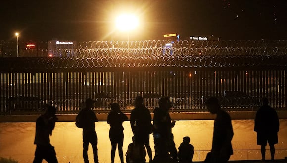 Migrantes camino a Estados Unidos el 8 de agosto esperan ser recibidos a través de un puente ferroviario en la frontera entre El Paso, Texas, y Ciudad Juárez, estado de Chihuahua, México, el 7 de agosto de 2023. (Foto de HERIKA MARTINEZ / AFP)
