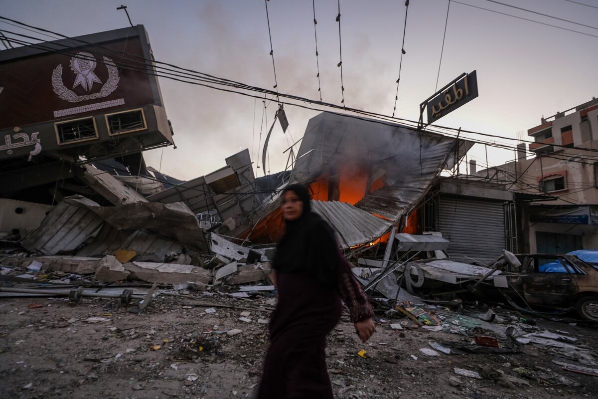 Una mujer palestina camina junto a una panadería destruida en el campo de refugiados de Al Nusairat, en el centro de la Franja de Gaza, el 18 de octubre de 2023. (Foto de EFE/EPA/MOHAMMED SABER)