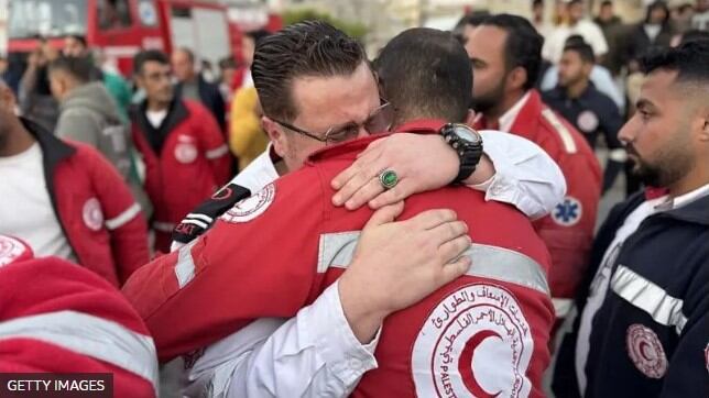Empleados de la Media Luna Roja Palestina se abrazan mientras trasladan los cuerpos de sus compañeros a Jan Yunis, en el sur de Gaza. (Getty Images).
