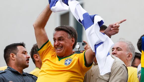 El expresidente de Brasil, Jair Bolsonaro, ondea una bandera de Israel durante una movilización donde reunió a miles de sus seguidores. (EFE/ Sebastiao Moreira).
