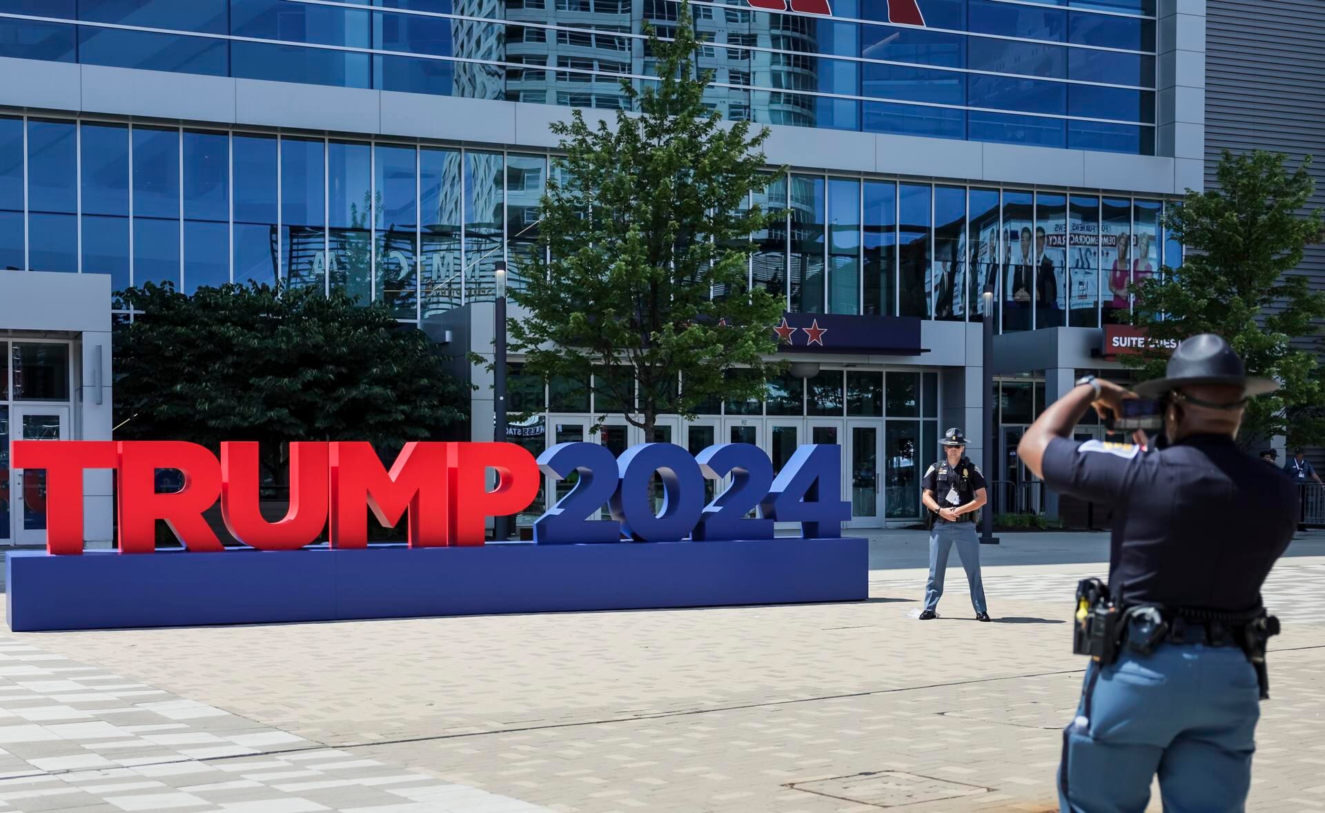 Agentes del Estado de Indiana toman fotografías cuando llegan para los preparativos para la Convención Nacional Republicana al Foro Fiserv en Milwaukee, Wisconsin, el 14 de julio de 2024. (EFE/EPA/ALLISON CENA).