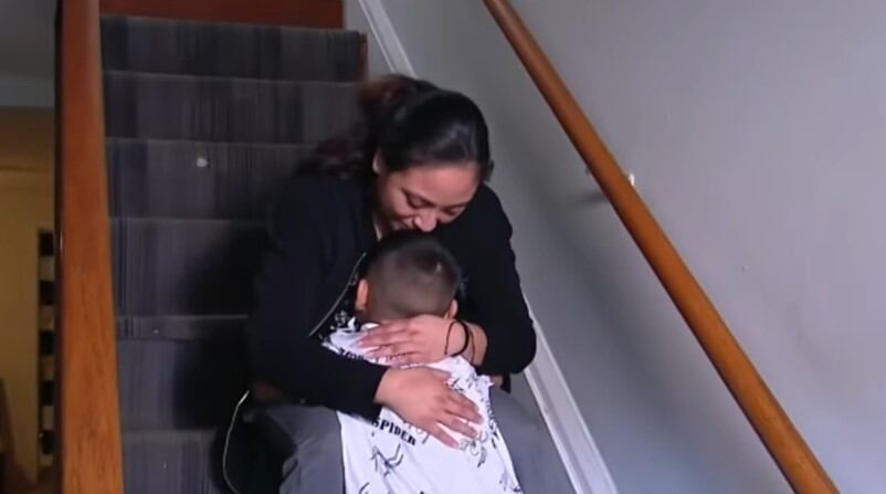 Dulce Díaz abrazando a su menor hijo de 5 años. No estuvo cerca de él durante 25 días. (Crédito: Noticias Telemundo / YouTube)