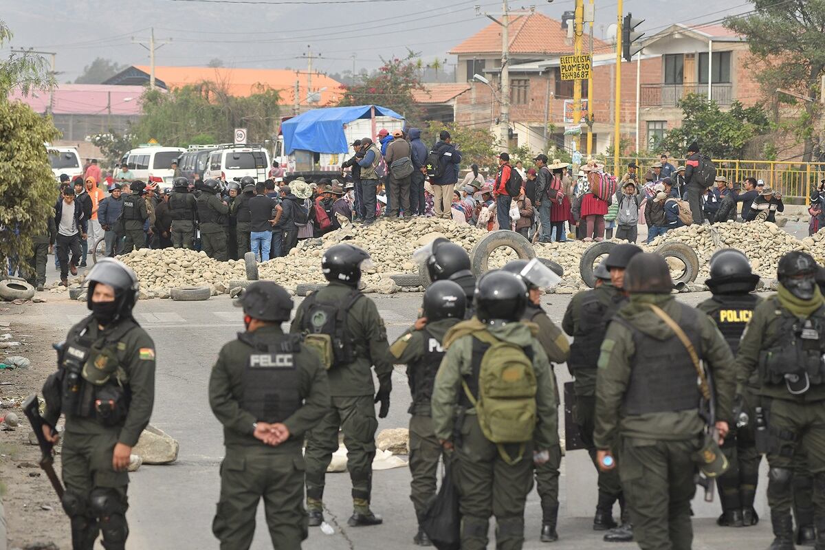 Agentes de la Policía intervienen uno de los bloqueos a una carretera por parte de seguidores del expresidente Evo Morales, en Vinto, Bolivia, el 22 de octubre de 2024. (Foto de Jorge Abrego / EFE)