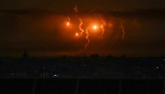 Bengalas lanzadas por las fuerzas israelíes iluminan el cielo sobre la ciudad de Gaza el 15 de noviembre de 2023, en medio de las batallas en curso entre Israel y el grupo palestino Hamás. (Foto de SAID KHATIB / AFP)