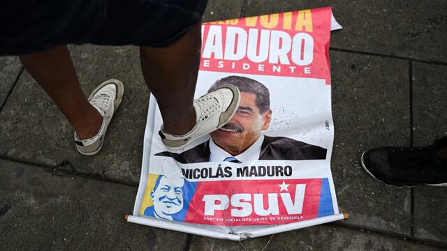 Un opositor al gobierno del presidente de Venezuela Nicolás Maduro pisa un cartel de campaña con su imagen durante una protesta en el barrio de Petare, en Caracas. (Foto de Raúl ARBOLEDA / AFP).