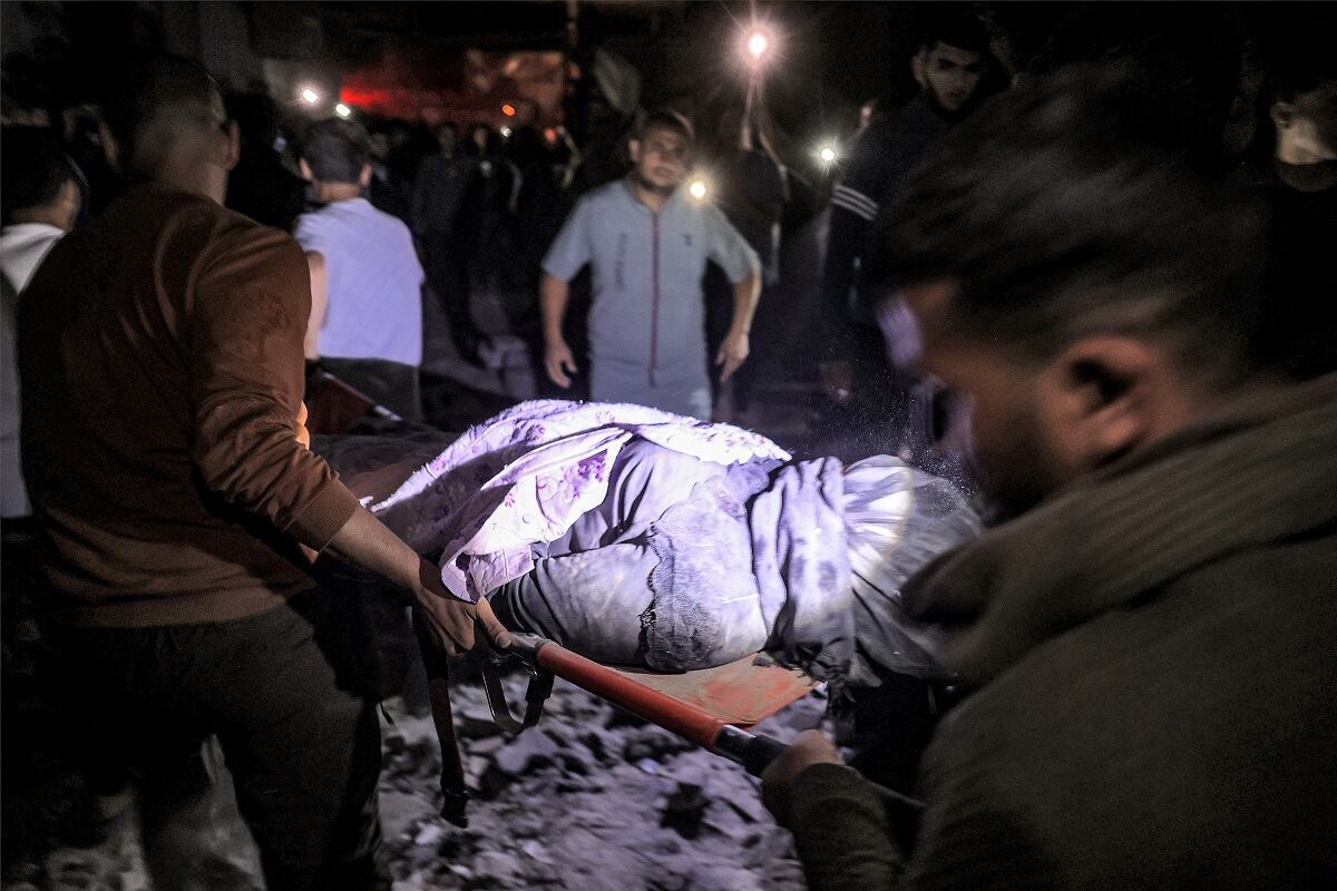 Gente lleva en una camilla el cuerpo de una víctima que murió en el lugar de un edificio alcanzado por un bombardeo israelí en Rafah, en el sur de la Franja de Gaza, el 7 de mayo de 2024. (Foto de AFP)
