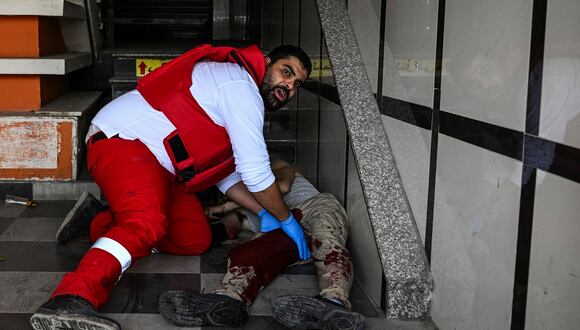 Un paramédico palestino atiende a un hombre herido durante una incursión del ejército israelí en Jenín dentro de un centro comercial en la ciudad ocupada del norte de Cisjordania, el 22 de mayo de 2024. (Foto de RONALDO SCHEMIDT / AFP)