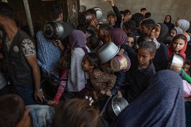 Cientos de palestinos se amontonan frente al Comedor Social Sokar en la Ciudad de Gaza para conseguir raciones limitadas de comida. (EFE/ Haitham Imad).