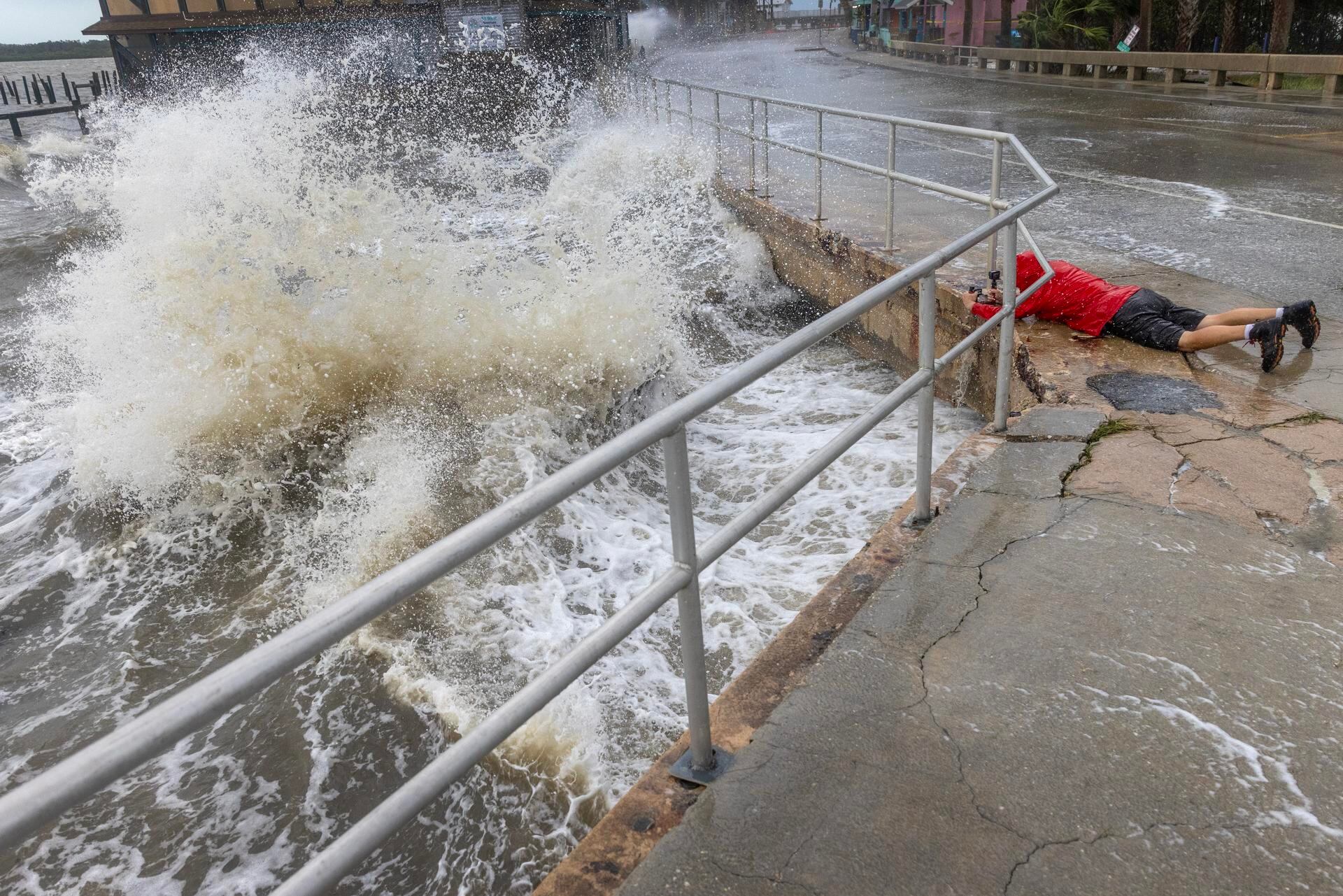 Un visitante desafía el oleaje, la marejada ciclónica y los fuertes vientos del huracán Helene para tomar fotografías en el centro de Cedar Key, Florida, EE.UU., el 26 de septiembre de 2024. EFE/EPA/CRISTOBAL HERRERA-ULASHKEVICH