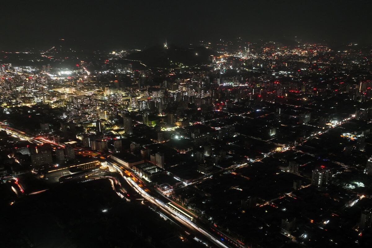 Esta vista aérea muestra la ciudad parcialmente iluminada durante un apagón en Santiago, Chile, el 25 de febrero de 2025. (Foto de Javier TORRES / AFP)