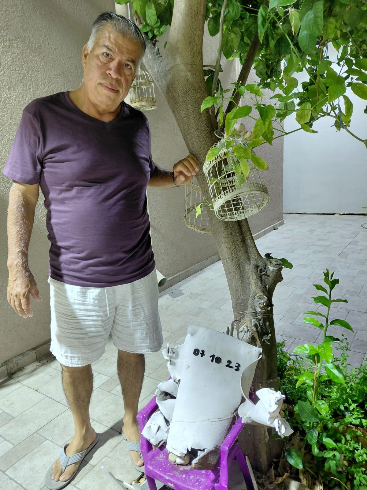 John Guerra, quien lleva 24 años en Israel, muestra una parte de un misil que cayó a un lado de su casa. (Foto: Archivo personal / Cortesía para El Comercio)
