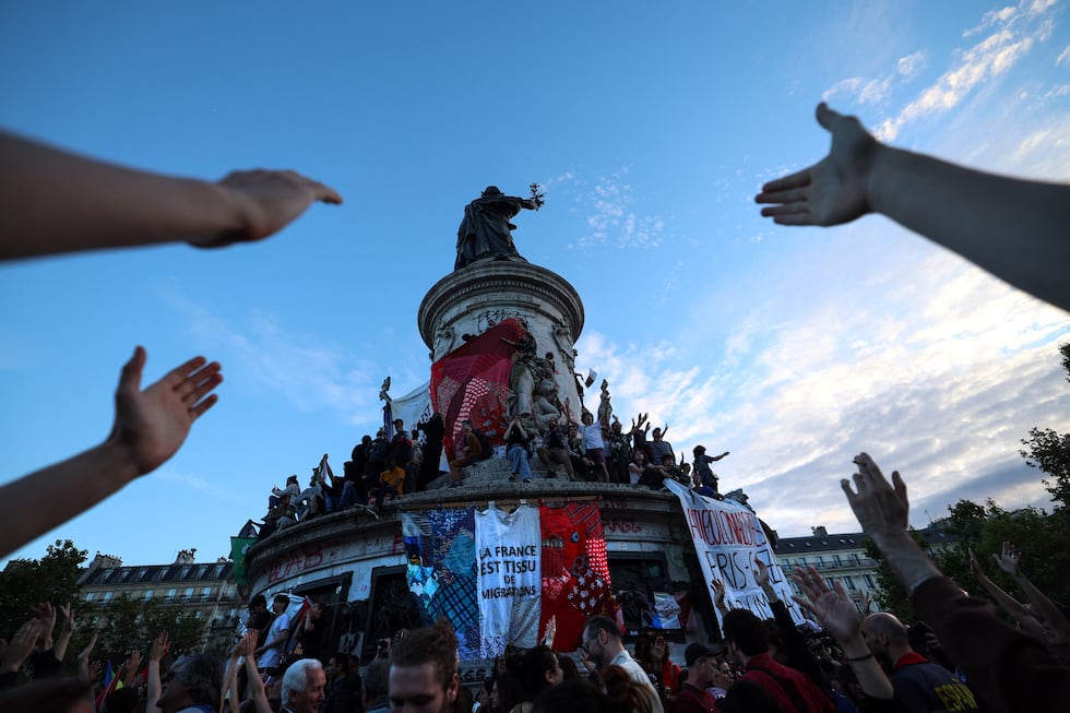 La gente celebra junto a una pancarta gigante que dice "Francia es el tejido de la migración", tras los primeros resultados de la segunda vuelta de las elecciones legislativas. (Foto de Emmanuel Dunand / AFP).