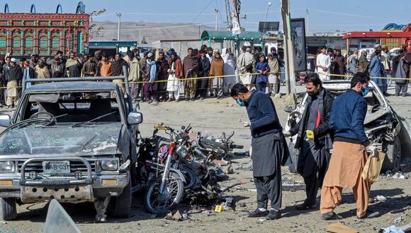 Los funcionarios recogen evidencias en el lugar de la explosión de una bomba frente a la oficina de un candidato independiente en el distrito de Pishin, a unos 50 kilómetros (30 millas) de Quetta el 7 de febrero de 2024, en vísperas de las elecciones nacionales de Pakistán. (Foto de Banaras KHAN / AFP)